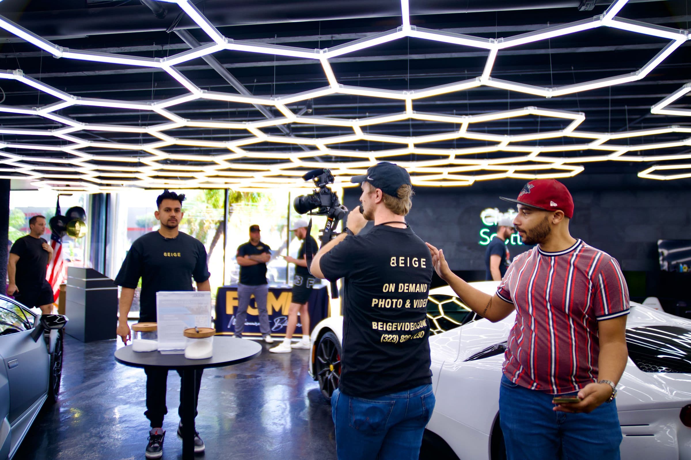 Behind the scenes of a car commercial, crew and camera under a hexagonal light rig