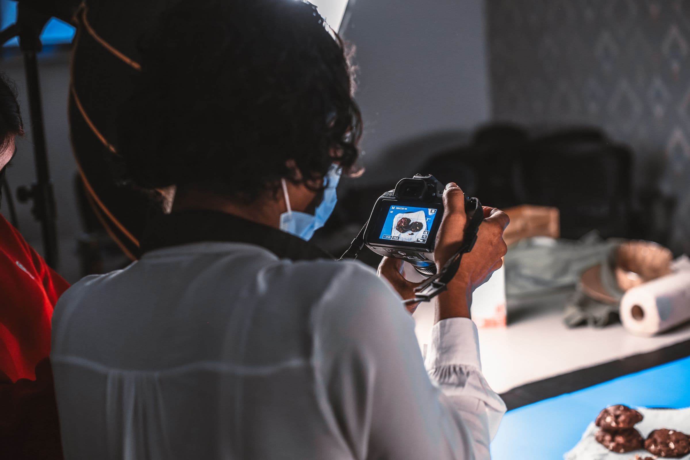 Photographer checking a shot on camera during a tabletop product shoot